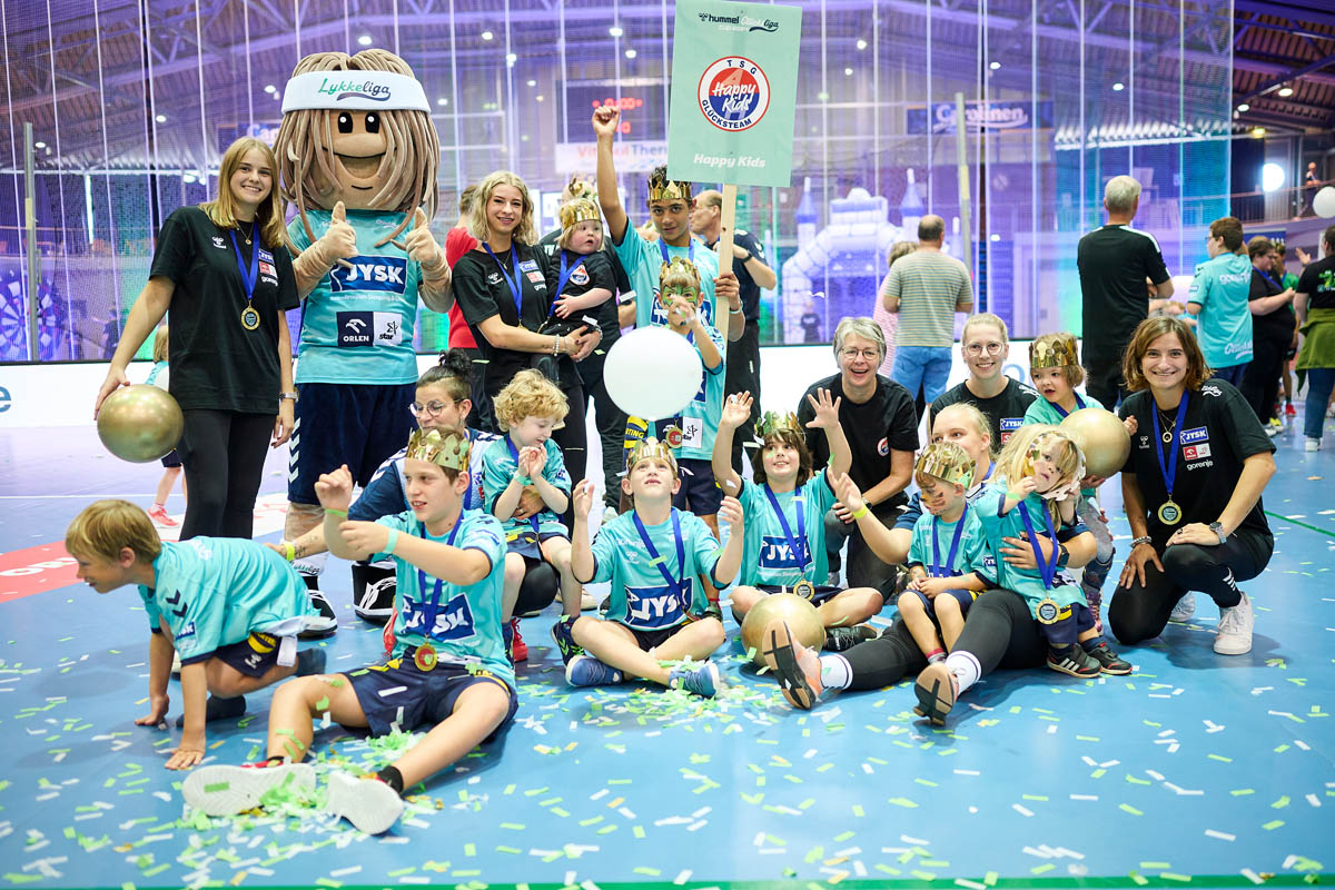 Glücksliga-Team Happy Kids mit Medaillen und Kronen mit dem Maskottchen der LykkeLiga