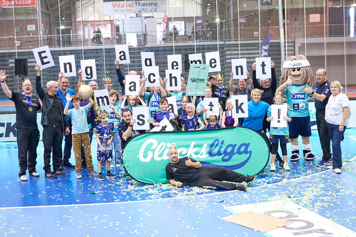 Teilnehmer des Glücksliga Cups halten Schilder mit Buchstaben hoch, die den Satz Engangement macht stark ergeben
